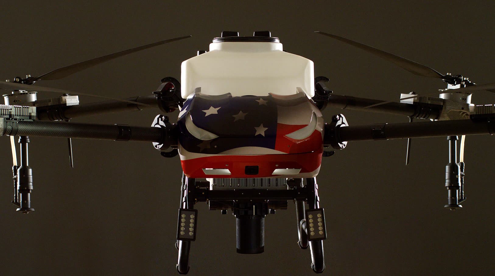 Terraplex I-19 spray drone head-on in a dark studio, stars and stripes livery across the tank shroud