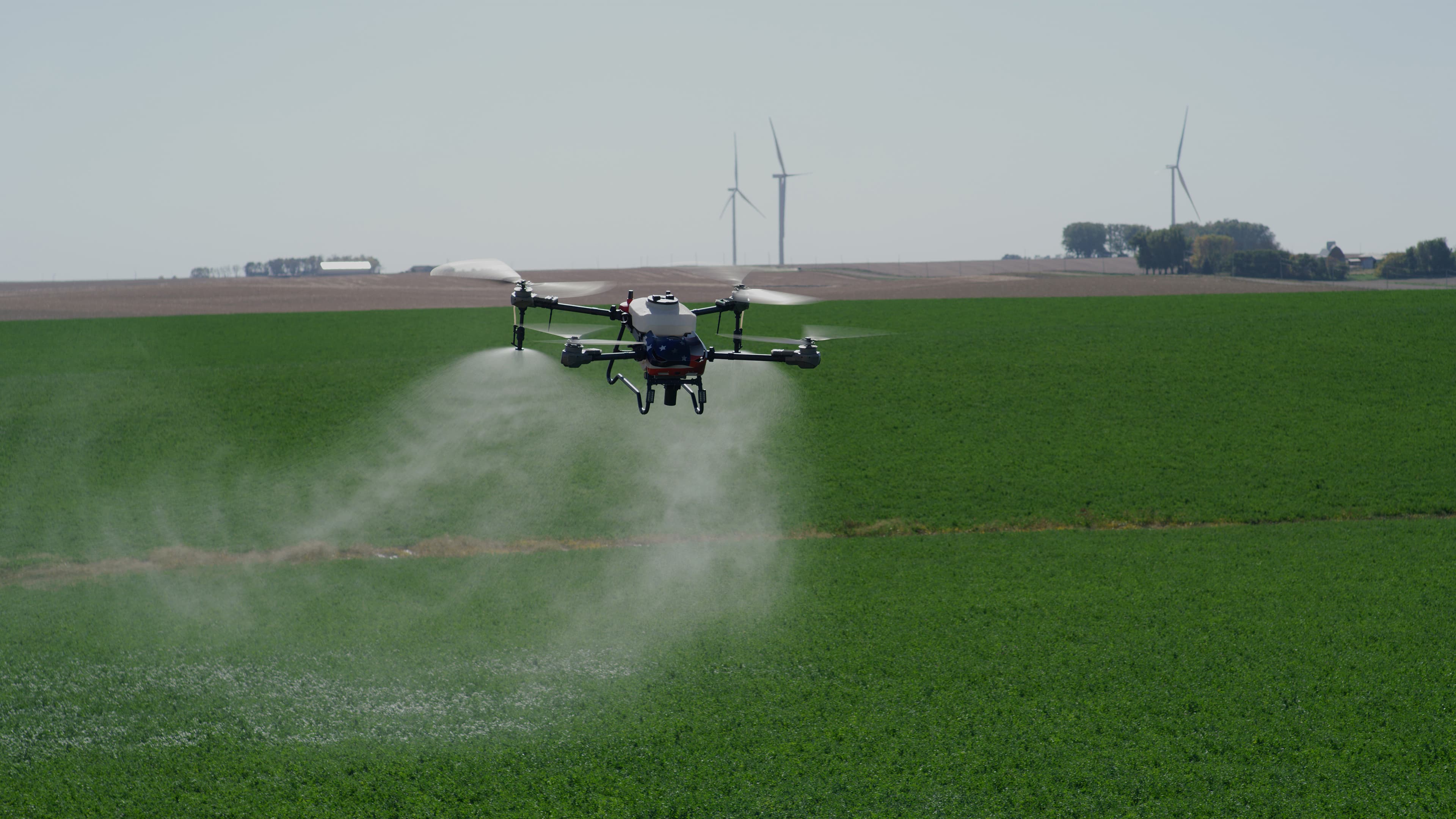 Terraplex I-19 spray drone applying over a green alfalfa field